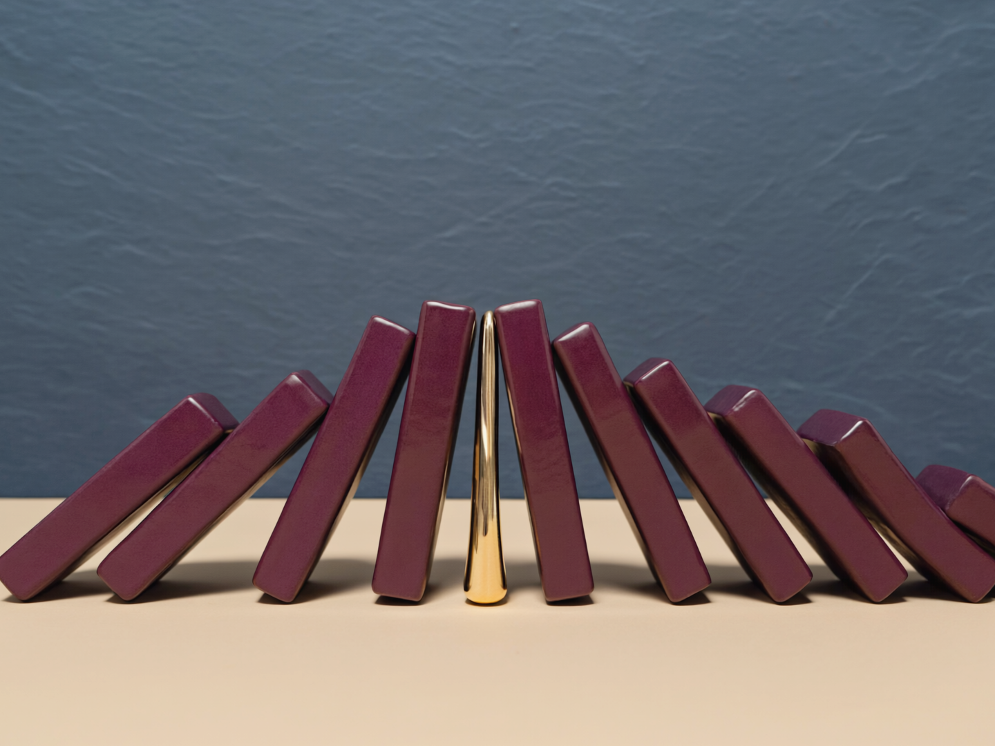A golden form calmly interrupting a cascade of plum dominoes